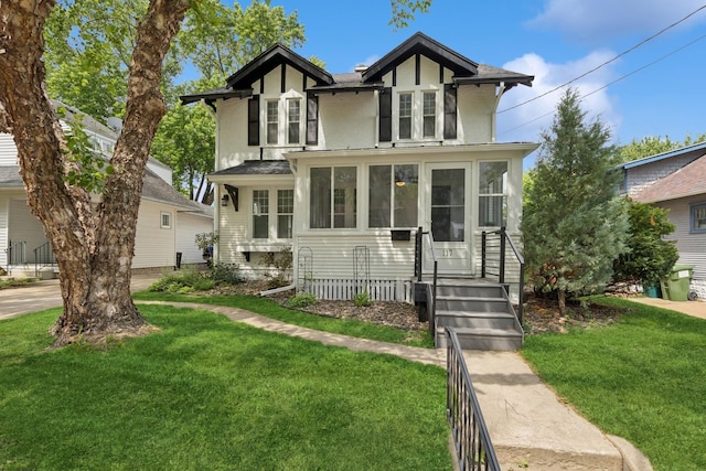 117 9th Ave NW, Rochester, MN 55901 - english style home with a front yard, stucco siding, and a sunroom
