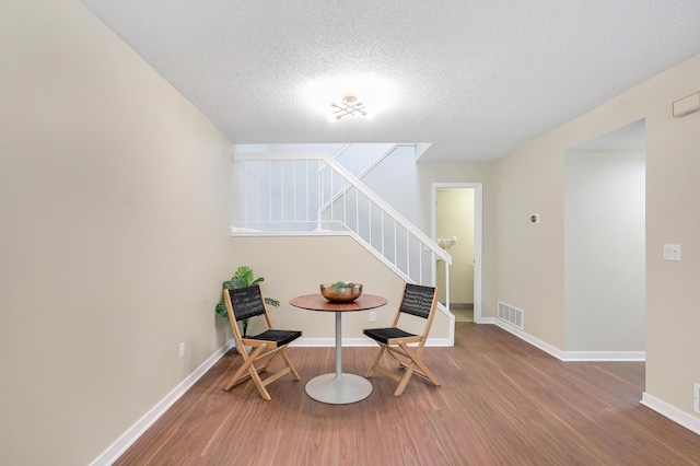 2145 Shenandoah Ct Unit D, Plymouth, MN 55447 - sitting room featuring wood finished floors, stairs, and a textured ceiling