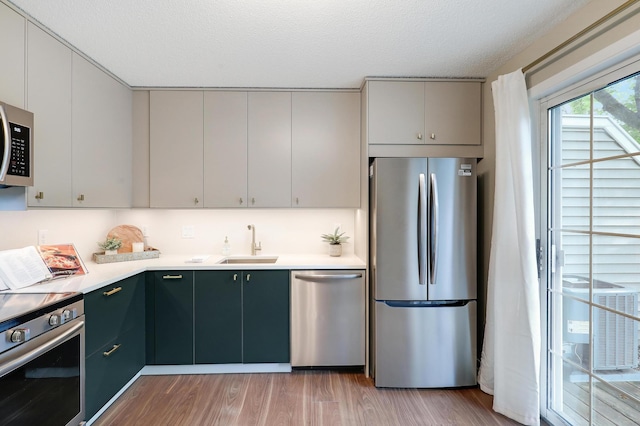 2145 Shenandoah Ct Unit D, Plymouth, MN 55447 - kitchen with stainless steel appliances, light countertops, light wood-style floors, and a textured ceiling