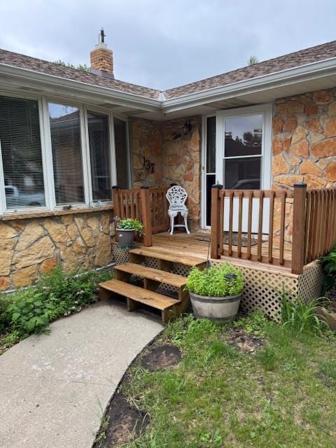 137 20th Ave S, Saint Cloud, MN 56301 - doorway to property with stone siding, a chimney, and a shingled roof