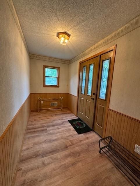 137 20th Ave S, Saint Cloud, MN 56301 - entryway featuring a wainscoted wall, wood finished floors, a textured ceiling, wood walls, and a textured wall