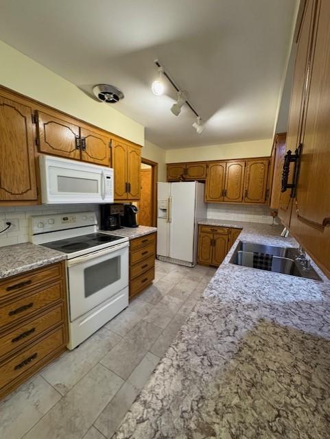 137 20th Ave S, Saint Cloud, MN 56301 - kitchen featuring white appliances, brown cabinetry, decorative backsplash, and track lighting
