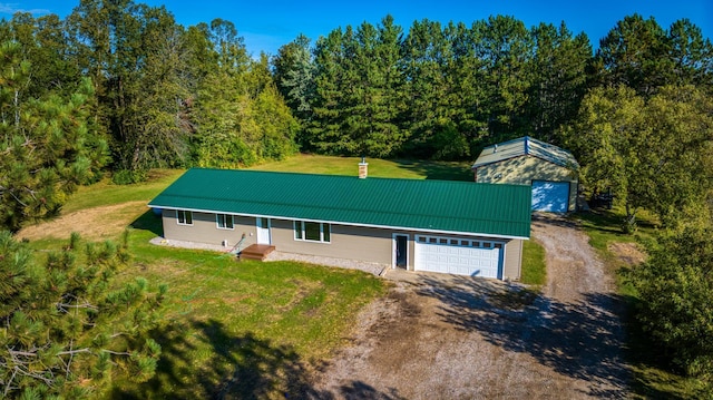 329 Kelliher Rd SW, Kelliher, MN 56650 - view of front of house featuring dirt driveway, a chimney, a front lawn, a garage, and a metal roof