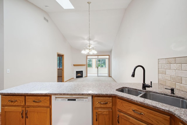 14208 Heritage Ln, Apple Valley, MN 55124 - kitchen featuring white dishwasher, high vaulted ceiling, open floor plan, a chandelier, and a warm lit fireplace