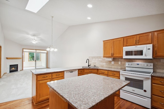 14208 Heritage Ln, Apple Valley, MN 55124 - kitchen with white appliances, a peninsula, vaulted ceiling, a skylight, and decorative backsplash