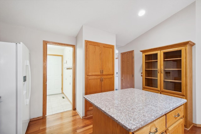 14208 Heritage Ln, Apple Valley, MN 55124 - kitchen with white refrigerator with ice dispenser, lofted ceiling, light wood-style flooring, light countertops, and a kitchen island