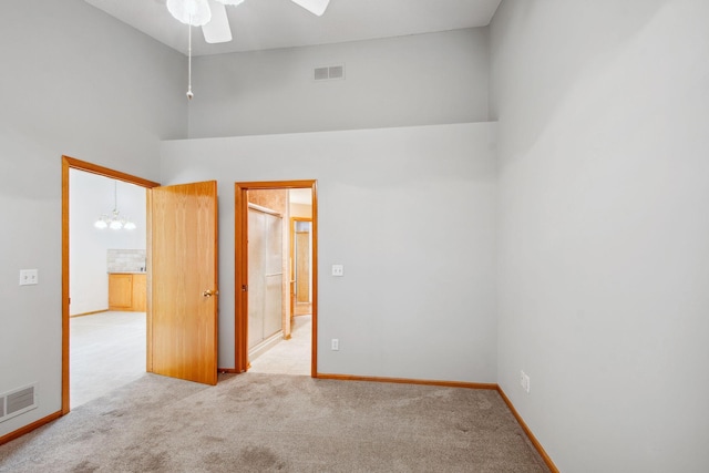 14208 Heritage Ln, Apple Valley, MN 55124 - empty room with high vaulted ceiling, carpet floors, ceiling fan, and a chandelier