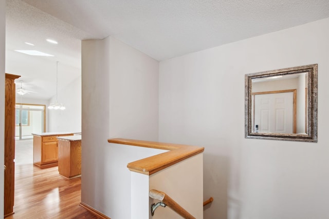 14208 Heritage Ln, Apple Valley, MN 55124 - hallway featuring light wood-style floors, an upstairs landing, and a chandelier
