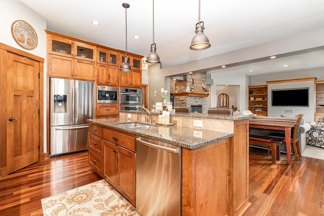 19270 Foxfield Dr, Credit River Twp, MN 55372 - kitchen featuring stainless steel appliances, open floor plan, brown cabinetry, wood finished floors, and recessed lighting