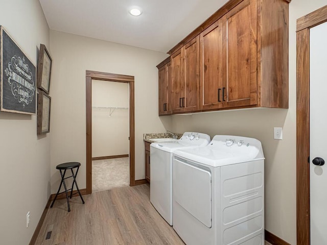 1136 168th Ln NW, Andover, MN 55304 - laundry area with washer and dryer, light wood-style flooring, and cabinet space