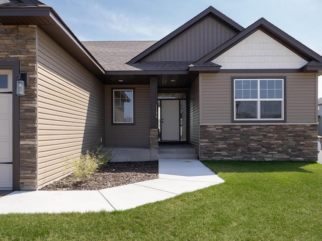 1136 168th Ln NW, Andover, MN 55304 - property entrance with stone siding, a yard, and roof with shingles
