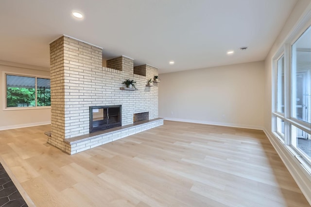 12258 Crooked Lake Blvd NW, Coon Rapids, MN 55433 - unfurnished living room featuring a brick fireplace, light wood-style flooring, and recessed lighting