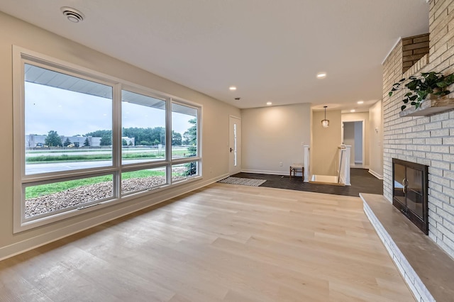 12258 Crooked Lake Blvd NW, Coon Rapids, MN 55433 - unfurnished living room with wood finished floors, a fireplace, and recessed lighting
