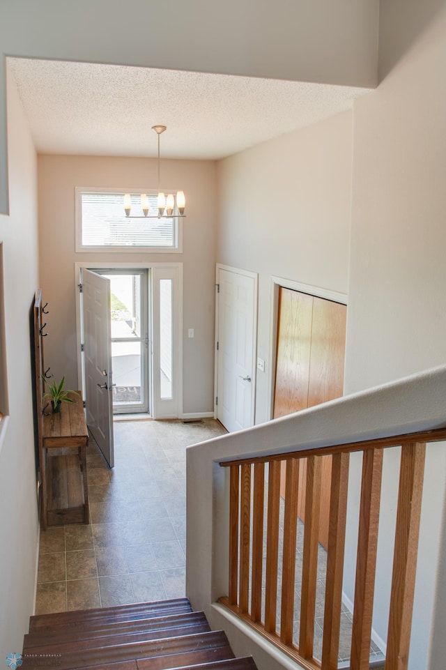 1083 Parkway Ln, West Fargo, ND 58078 - entryway with a chandelier, a textured ceiling, and tile patterned flooring