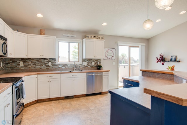 1083 Parkway Ln, West Fargo, ND 58078 - kitchen featuring appliances with stainless steel finishes, healthy amount of natural light, backsplash, recessed lighting, and white cabinetry