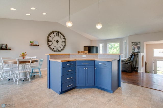 1083 Parkway Ln, West Fargo, ND 58078 - kitchen featuring light countertops, vaulted ceiling, blue cabinetry, light tile patterned flooring, and hanging light fixtures