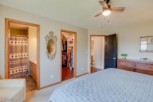 1083 Parkway Ln, West Fargo, ND 58078 - bedroom with a walk in closet, ensuite bathroom, carpet flooring, a closet, and ceiling fan