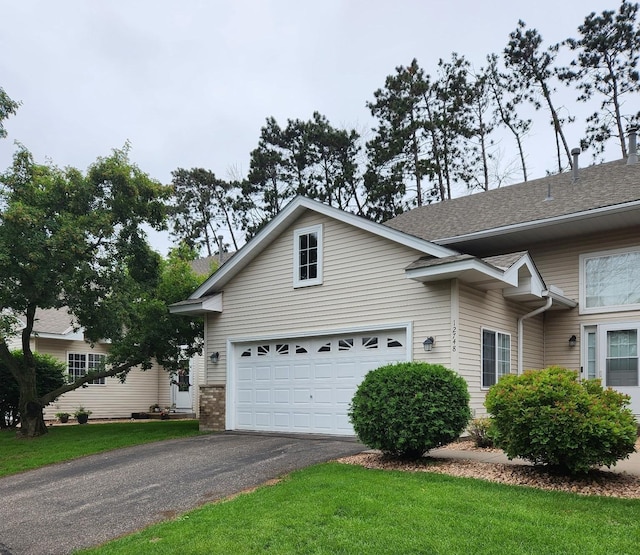 12748 Ulysses Cir NE, Blaine, MN 55434 - view of front facade featuring driveway, a garage, a front lawn, and roof with shingles