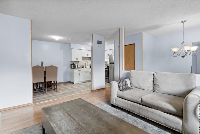 4421 Cinnamon Ridge Cir, Eagan, MN 55122 - living area with a chandelier, light wood-style flooring, and a textured ceiling