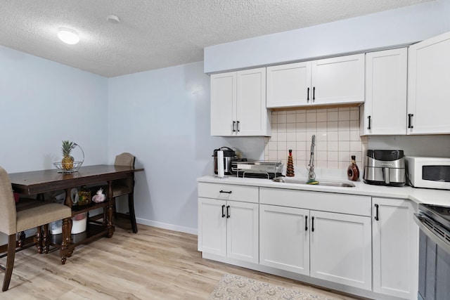 4421 Cinnamon Ridge Cir, Eagan, MN 55122 - kitchen featuring white microwave, electric stove, tasteful backsplash, white cabinetry, and a textured ceiling