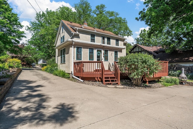 123 Franklin Ave, Owatonna, MN 55060 - view of front facade featuring stucco siding, a wooden deck, and a chimney