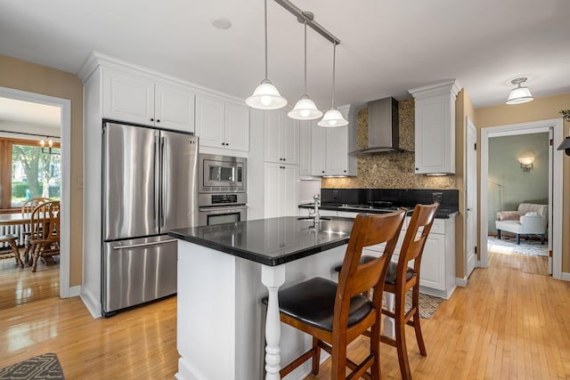 123 Franklin Ave, Owatonna, MN 55060 - kitchen with stainless steel appliances, wall chimney range hood, light wood-style floors, tasteful backsplash, and white cabinets