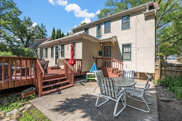 123 Franklin Ave, Owatonna, MN 55060 - rear view of house with stucco siding, a wooden deck, and outdoor dining area