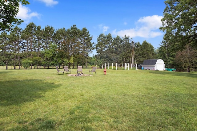 23481 Fontana St NE, Linwood Twp, MN 55079 - view of green lawn featuring a shed, an outdoor fire pit, and view of scattered trees