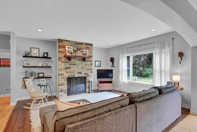 35853 Whispering Pine Way, Florence Twp, MN 55041 - living room featuring a stone fireplace, hardwood / wood-style flooring, recessed lighting, and arched walkways