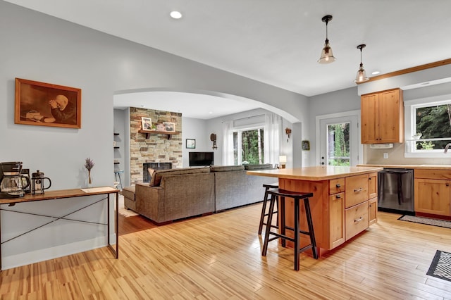 35853 Whispering Pine Way, Florence Twp, MN 55041 - kitchen with dishwasher, arched walkways, a kitchen breakfast bar, a kitchen island, and a stone fireplace