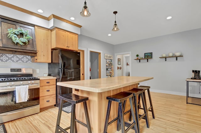 35853 Whispering Pine Way, Florence Twp, MN 55041 - kitchen featuring stainless steel gas range oven, light brown cabinets, light countertops, freestanding refrigerator, and light wood-style floors