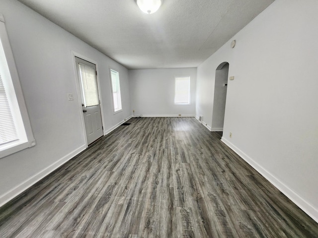 1222 8th Ave SE, Rochester, MN 55904 - empty room with arched walkways, dark wood-style floors, and a textured ceiling