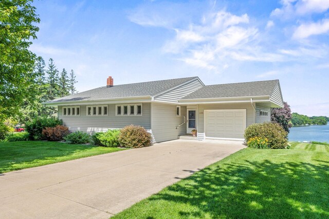 830 Willis St, Dassel, MN 55325 - ranch-style home featuring an attached garage, concrete driveway, a chimney, a front lawn, and roof with shingles