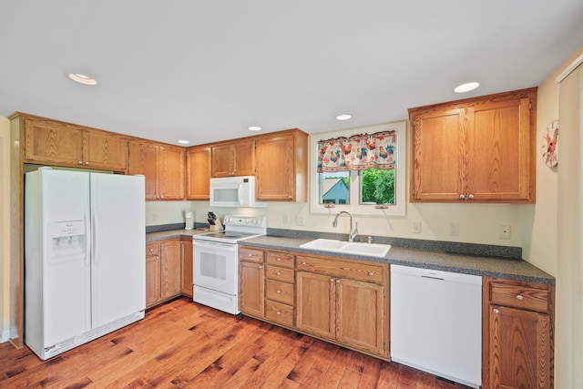 830 Willis St, Dassel, MN 55325 - kitchen with white appliances, recessed lighting, light wood-style floors, dark countertops, and brown cabinets