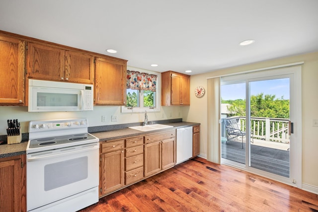 830 Willis St, Dassel, MN 55325 - kitchen featuring white appliances, light wood-style floors, healthy amount of natural light, brown cabinets, and recessed lighting
