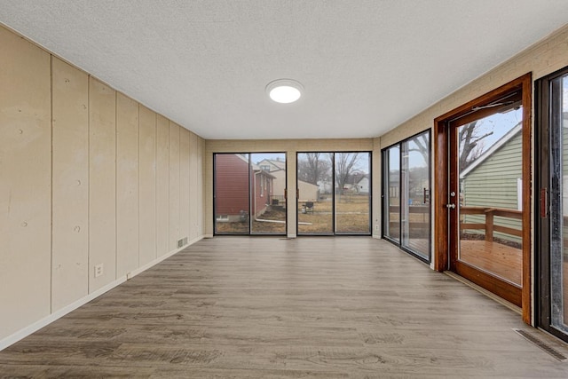 710 Jefferson St, New Ulm, MN 56073 - unfurnished room featuring wood finished floors, a textured ceiling, and healthy amount of natural light