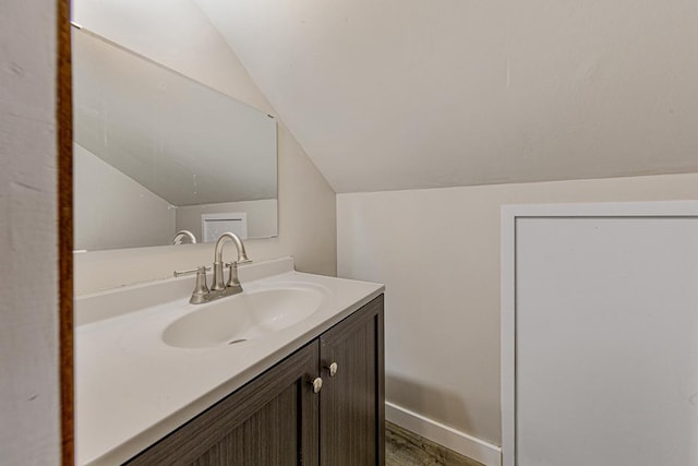 710 Jefferson St, New Ulm, MN 56073 - bathroom with vaulted ceiling, vanity, and wood finished floors