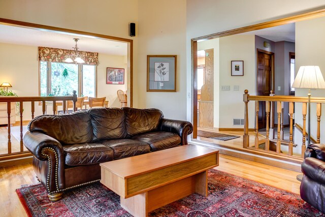 13445 190th Ave NW, Elk River, MN 55330 - living room featuring wood finished floors, a chandelier, and a high ceiling