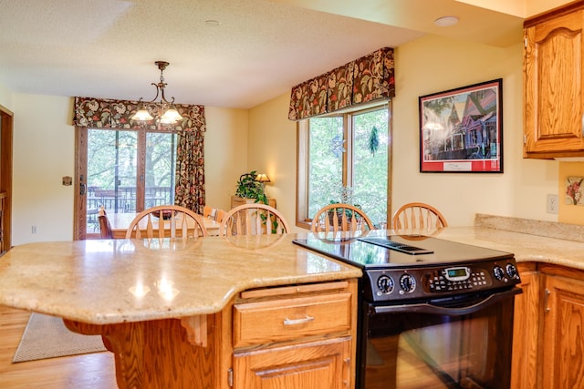 13445 190th Ave NW, Elk River, MN 55330 - kitchen with black electric range oven, a breakfast bar, plenty of natural light, wood finished floors, and a textured ceiling