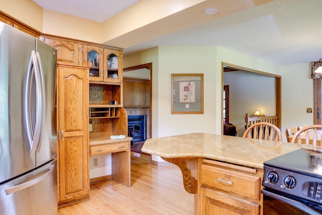 13445 190th Ave NW, Elk River, MN 55330 - kitchen with freestanding refrigerator, range, light wood-style flooring, a kitchen bar, and glass insert cabinets