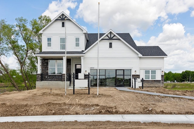 14700 105th Pl N, Maple Grove, MN 55369 - view of front of home with stone siding, a porch, and roof with shingles