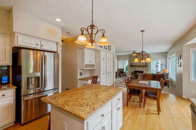 8017 Lismore Cir, Eden Prairie, MN 55347 - kitchen featuring stainless steel fridge, a large fireplace, light wood-style floors, a center island, and open floor plan