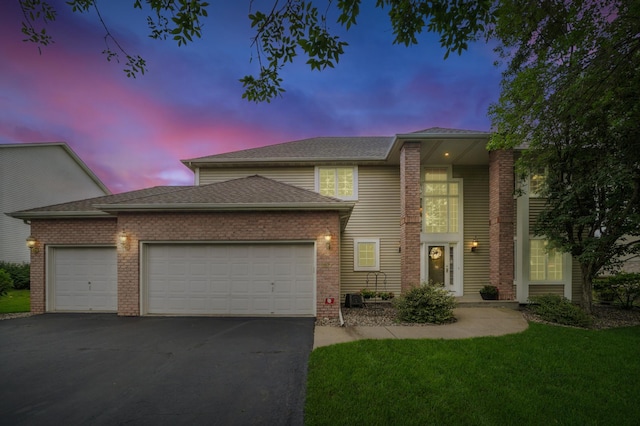 8017 Lismore Cir, Eden Prairie, MN 55347 - view of front facade featuring a garage, driveway, a lawn, a shingled roof, and brick siding