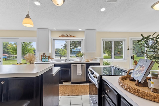 12329 Timber Ln, Maple Grove, MN 55369 - kitchen featuring stainless steel appliances, light countertops, light tile patterned flooring, a textured ceiling, and pendant lighting