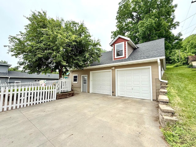 215 1st St N, Cannon Falls, MN 55009 - view of front of house with a shingled roof, an outdoor structure, and a detached garage