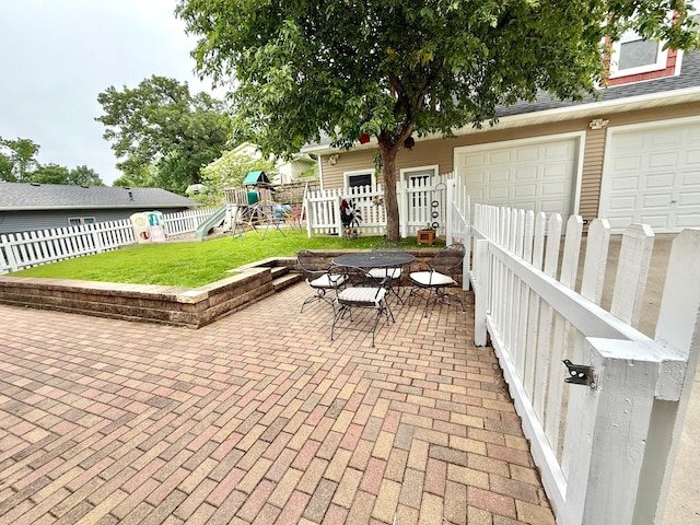 215 1st St N, Cannon Falls, MN 55009 - fenced backyard with a playground, outdoor dining space, a patio area, and a garage