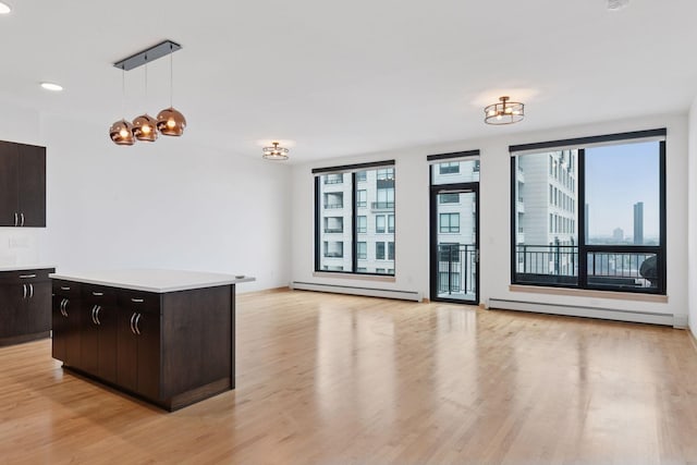 1240 2nd St Unit 1024, Minneapolis, MN 55415 - kitchen featuring a baseboard heating unit, light wood-style flooring, light countertops, pendant lighting, and recessed lighting