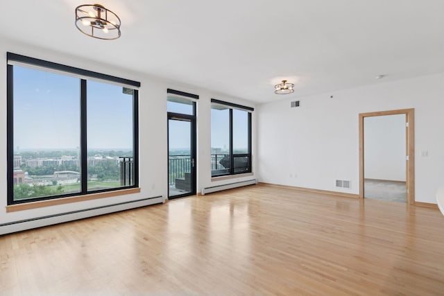 1240 2nd St Unit 1024, Minneapolis, MN 55415 - spare room featuring plenty of natural light, a baseboard heating unit, and light wood-type flooring