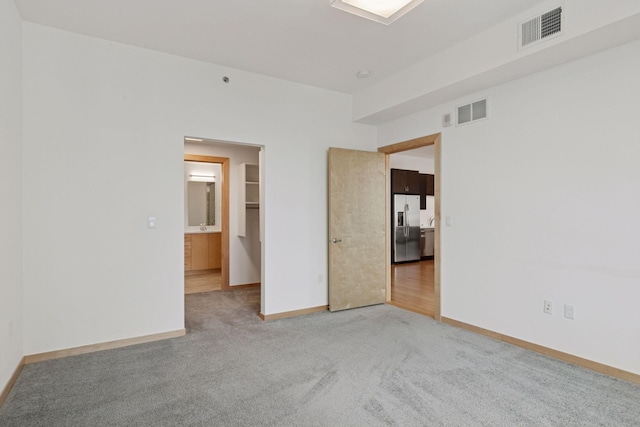 1240 2nd St Unit 1024, Minneapolis, MN 55415 - unfurnished bedroom with stainless steel fridge with ice dispenser and light carpet