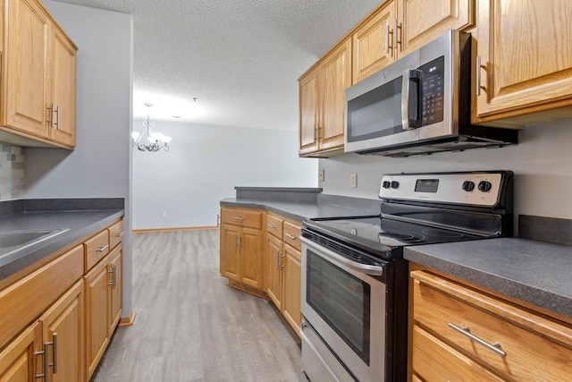 10787 Unity Ln N, Brooklyn Park, MN 55443 - kitchen with stainless steel appliances, dark countertops, a chandelier, light wood-style floors, and a textured ceiling